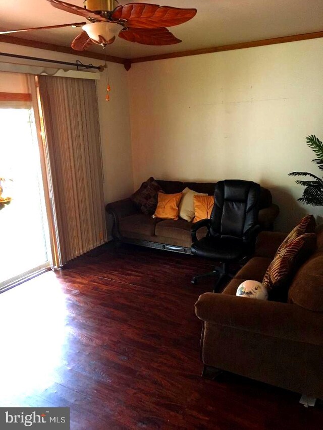 living room with crown molding, wood-type flooring, and ceiling fan