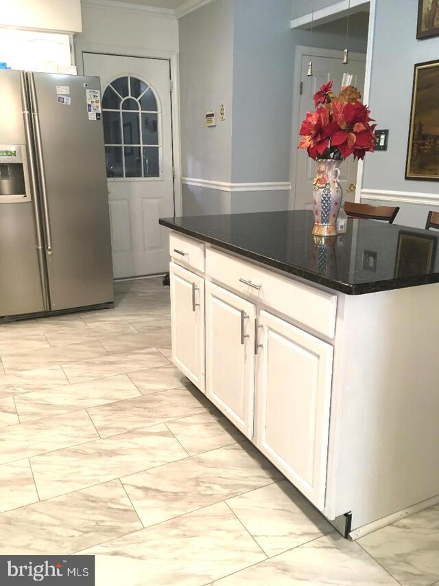 kitchen featuring dark stone countertops, ornamental molding, stainless steel fridge with ice dispenser, and white cabinets