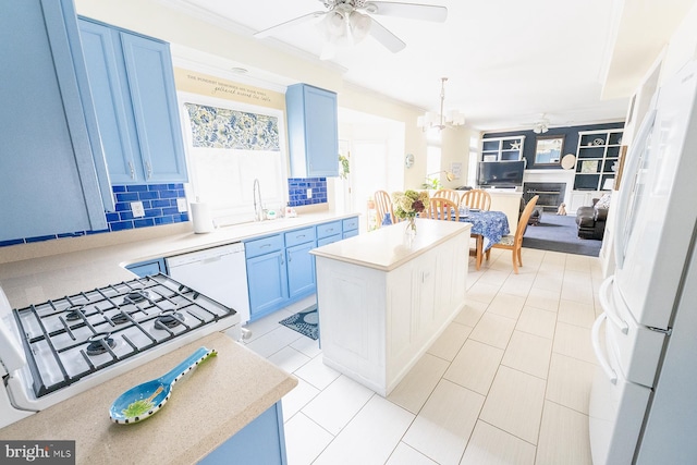 kitchen featuring ceiling fan with notable chandelier, white appliances, a center island, and tasteful backsplash