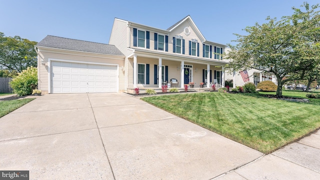 colonial home with a front yard, a garage, and covered porch