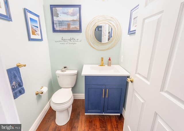 bathroom with wood-type flooring, vanity, and toilet