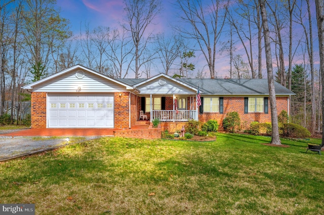 ranch-style house with a garage, a yard, and covered porch