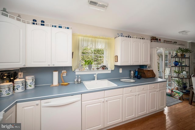 kitchen with white dishwasher, white cabinetry, sink, and dark hardwood / wood-style floors