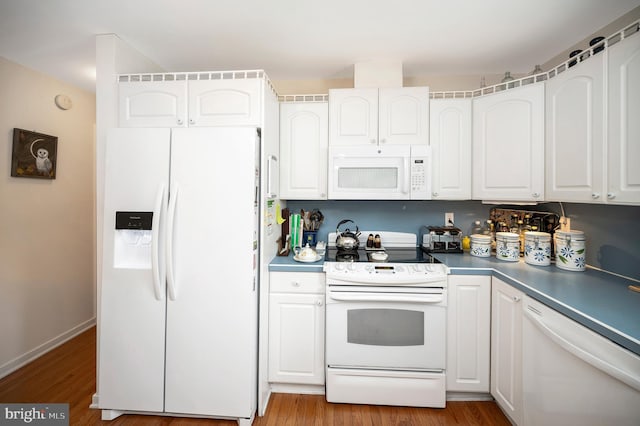 kitchen with hardwood / wood-style floors, white appliances, and white cabinetry