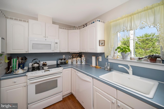 kitchen featuring dark hardwood / wood-style floors, sink, white appliances, and white cabinetry