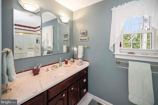 bathroom featuring walk in shower and vanity