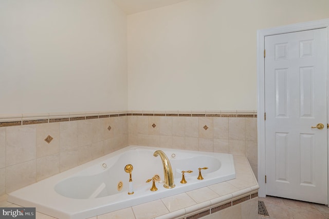 bathroom with a relaxing tiled tub and tile patterned floors