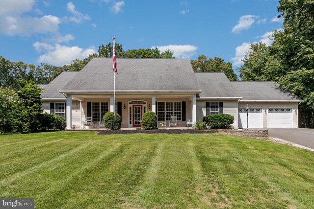 cape cod-style house with a porch, a front yard, and a garage