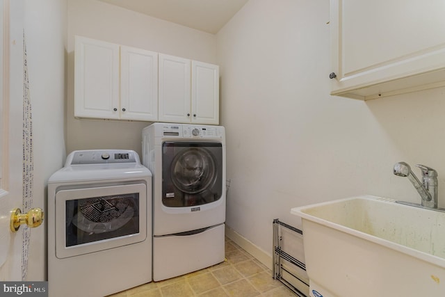 laundry area with light tile patterned flooring, sink, separate washer and dryer, and cabinets