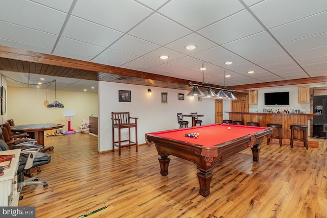 playroom featuring billiards, light hardwood / wood-style floors, a drop ceiling, and bar area