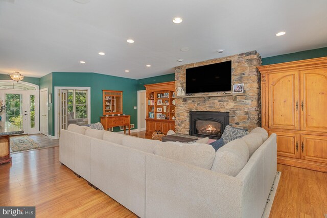 living room with a fireplace and light wood-type flooring