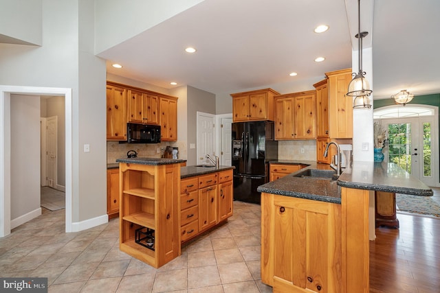 kitchen with sink, hanging light fixtures, tasteful backsplash, kitchen peninsula, and black appliances