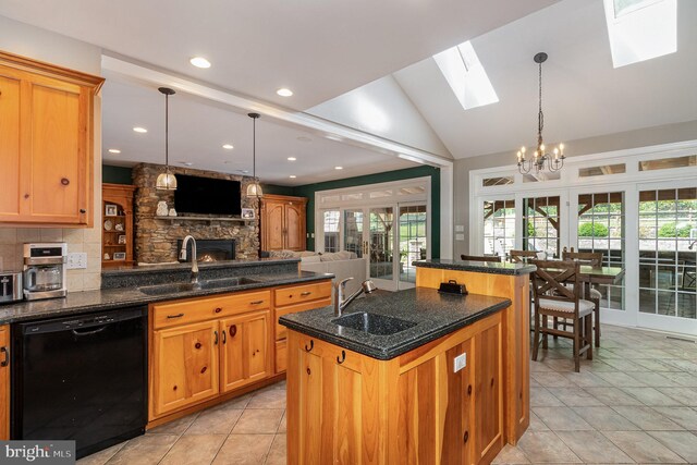 kitchen with sink, a fireplace, a kitchen island with sink, and dishwasher