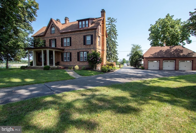 view of front of property featuring brick siding, a chimney, a porch, a front yard, and a garage