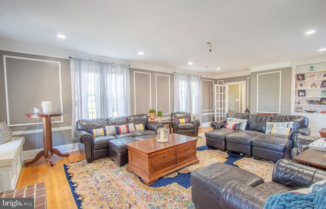 living area with baseboards, recessed lighting, light wood-type flooring, and crown molding