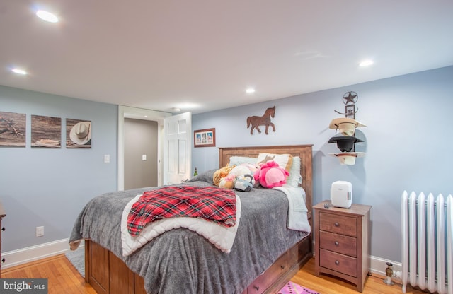 bedroom with baseboards, light wood-style floors, recessed lighting, and radiator