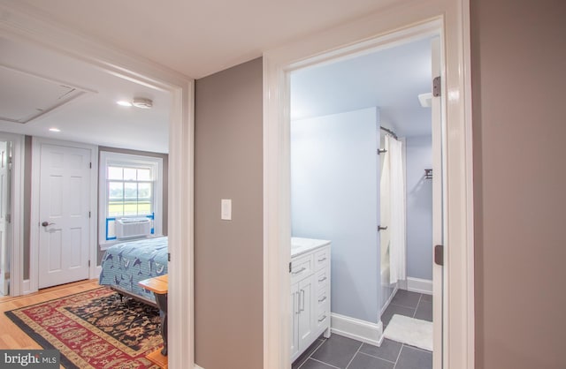 hall featuring cooling unit, dark tile patterned floors, and baseboards