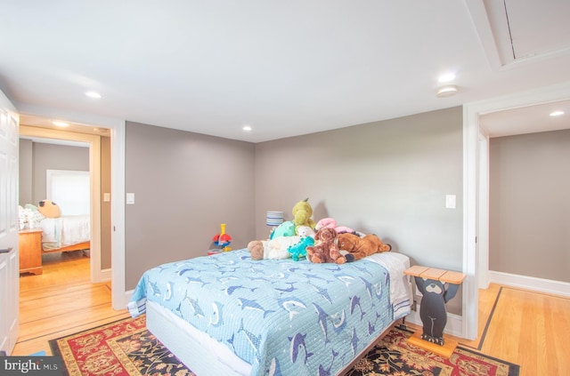 bedroom with attic access, recessed lighting, baseboards, and light wood finished floors