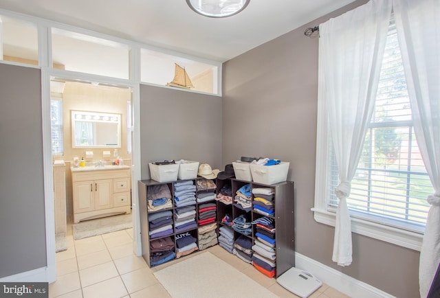 interior space with plenty of natural light, tile patterned flooring, vanity, and baseboards