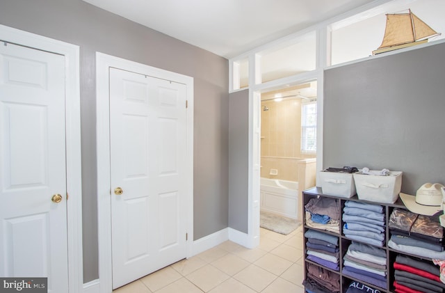 full bath with a garden tub, baseboards, and tile patterned floors