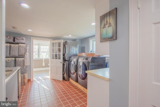 laundry area with light tile patterned floors, cabinet space, baseboards, washer and clothes dryer, and recessed lighting