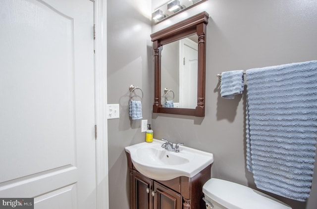 half bathroom featuring toilet and vanity