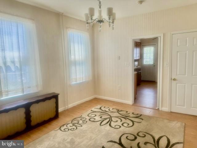 interior space with light hardwood / wood-style flooring and a notable chandelier