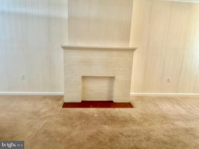 room details featuring carpet floors and a brick fireplace