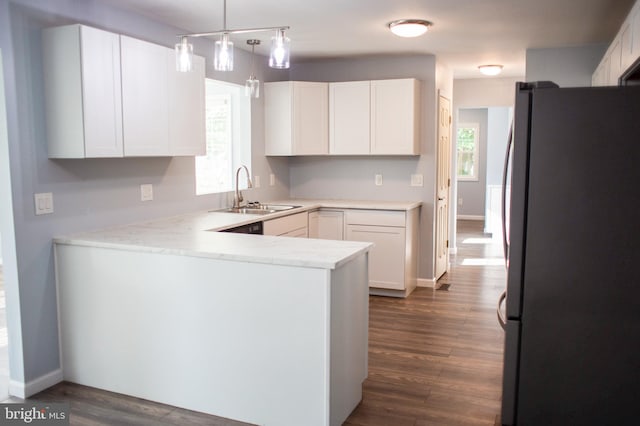 kitchen with white cabinets, stainless steel refrigerator, sink, dark hardwood / wood-style floors, and kitchen peninsula