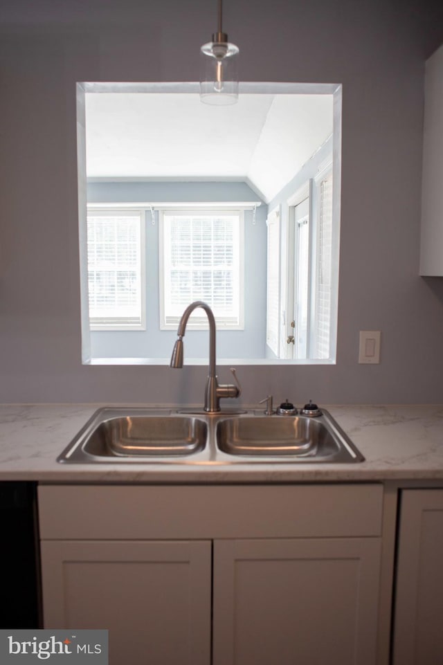 kitchen featuring lofted ceiling and sink