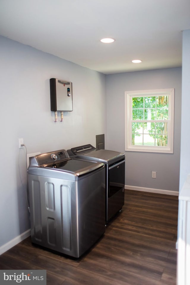 laundry room with washing machine and clothes dryer and dark hardwood / wood-style floors