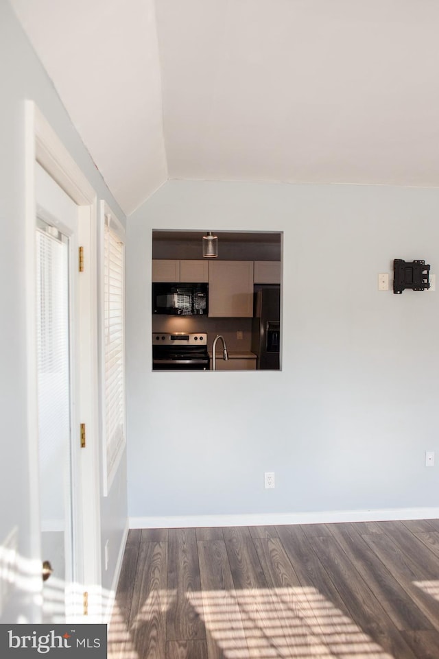 unfurnished living room featuring sink, dark hardwood / wood-style flooring, and vaulted ceiling