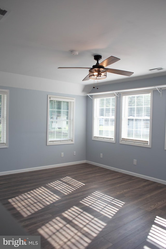 empty room with ceiling fan and dark hardwood / wood-style floors