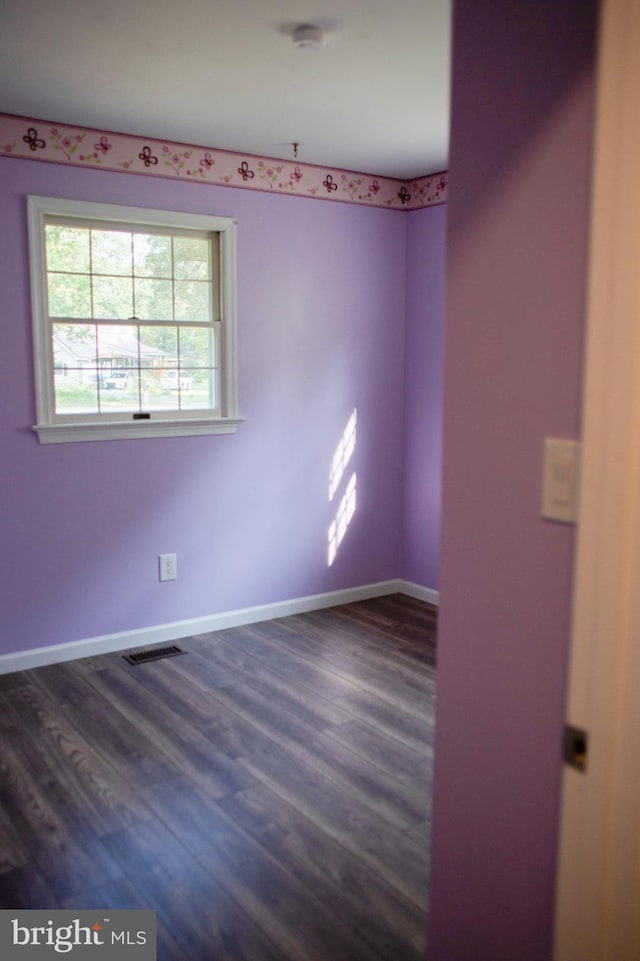 spare room featuring dark wood-type flooring