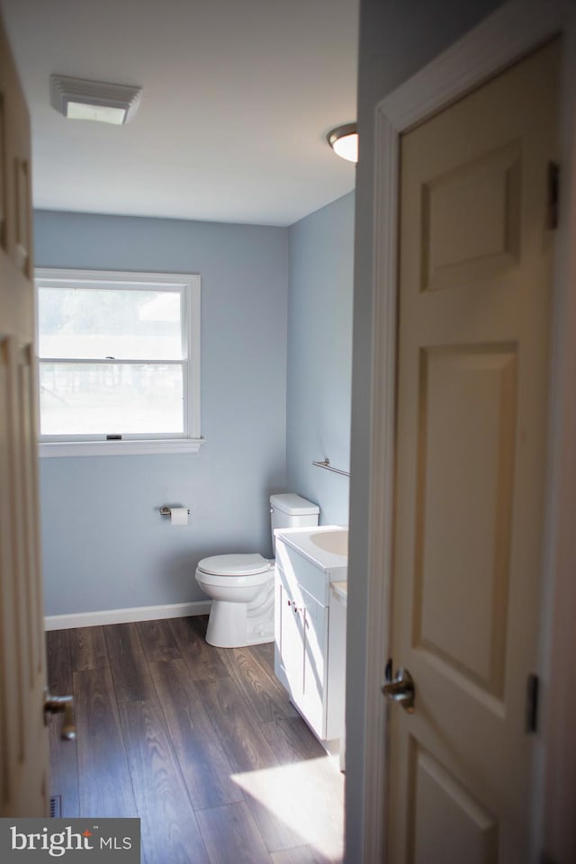 bathroom featuring vanity, toilet, and hardwood / wood-style floors