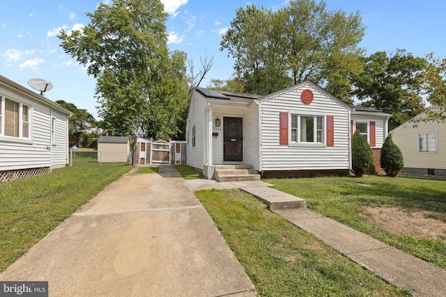 bungalow with solar panels, a front yard, a gate, and fence