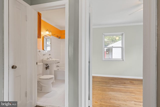 bathroom featuring toilet, wood-type flooring, tub / shower combination, ceiling fan, and ornamental molding