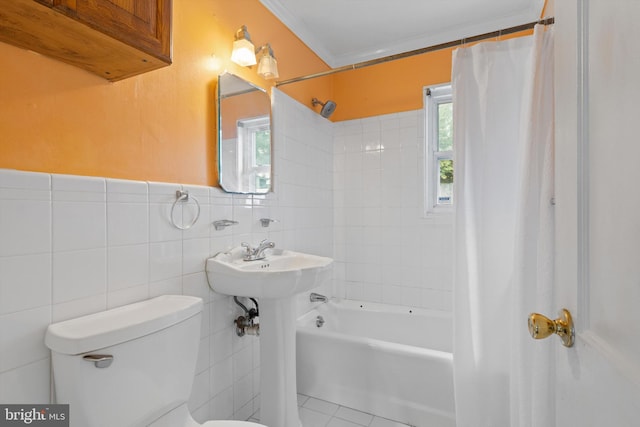 bathroom featuring tile walls, toilet, a wealth of natural light, and shower / tub combo with curtain