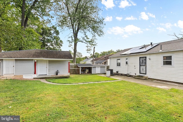 back of house with a lawn and a patio area