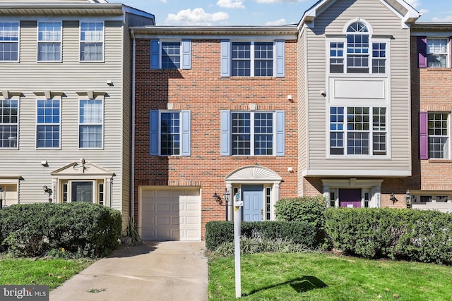 view of property featuring a garage and a front lawn