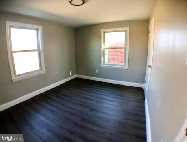 unfurnished room with dark hardwood / wood-style flooring