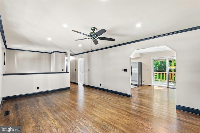 unfurnished room with baseboards, visible vents, dark wood-type flooring, and crown molding