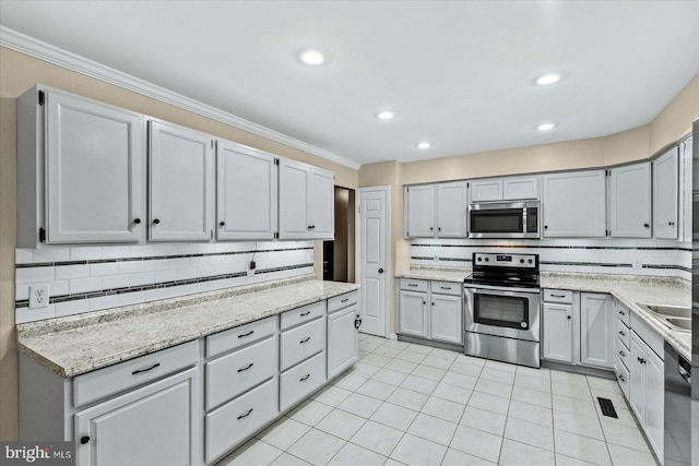 kitchen featuring stainless steel appliances, light tile patterned flooring, crown molding, and decorative backsplash