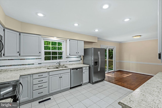 kitchen featuring decorative backsplash, appliances with stainless steel finishes, light countertops, gray cabinetry, and a sink