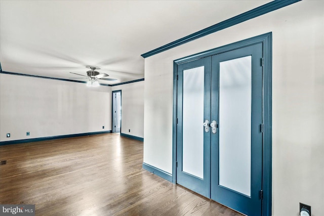 spare room featuring french doors, crown molding, visible vents, wood finished floors, and baseboards