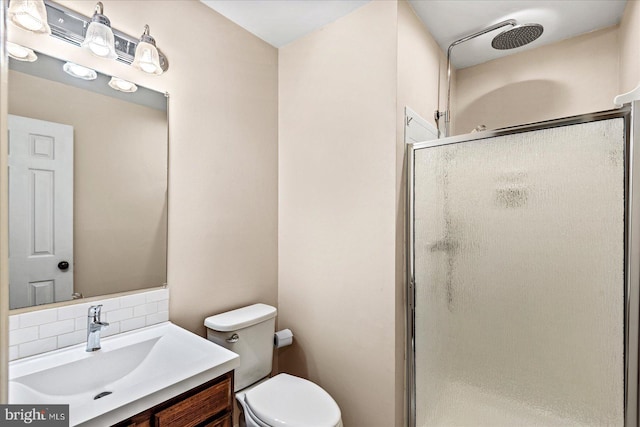 bathroom with toilet, a shower stall, decorative backsplash, and vanity