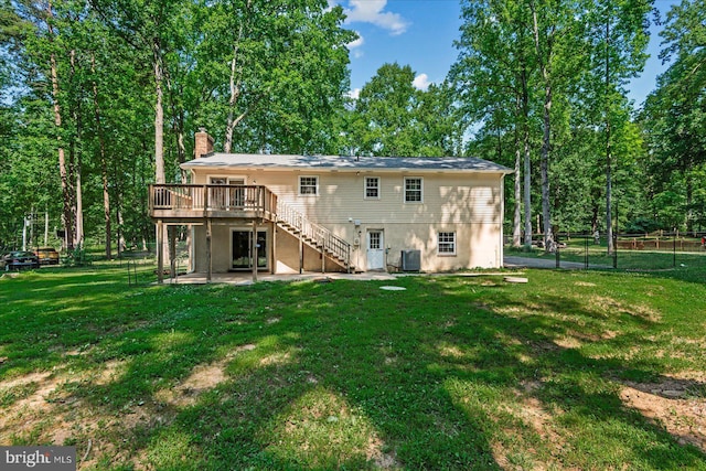 back of house featuring stairs, a deck, and a lawn