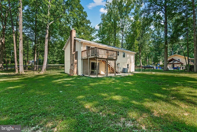 rear view of house with a deck, fence, a yard, stairway, and a chimney