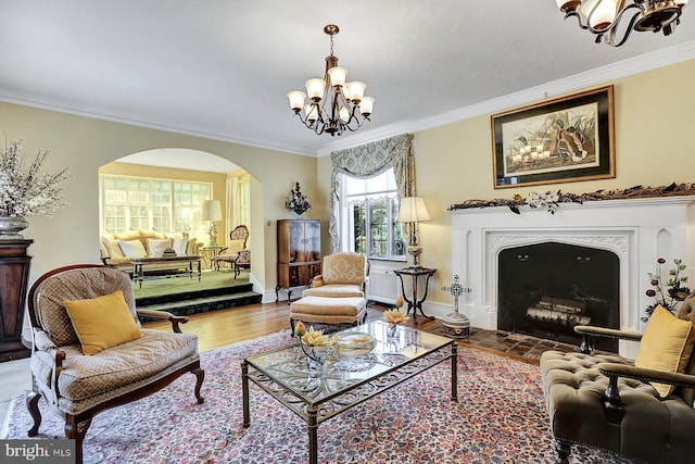 sitting room with wood-type flooring, ornamental molding, and a chandelier