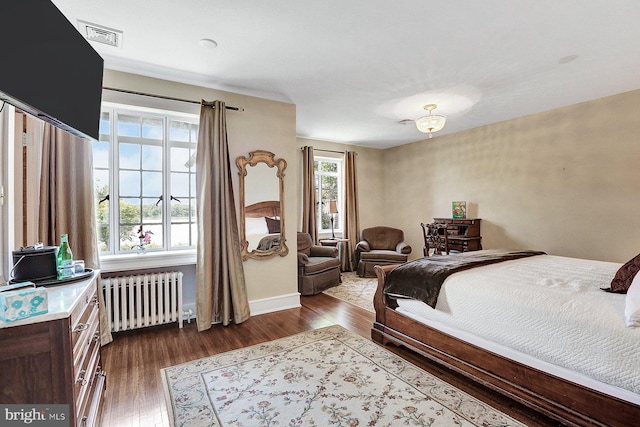 bedroom with radiator and dark wood-type flooring